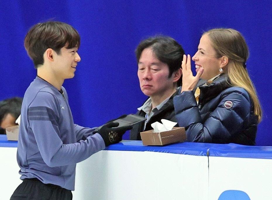 　公式練習でカロリナ・コストナーコーチ（右）と笑顔で話す鍵山優真。中央は鍵山正和コーチ