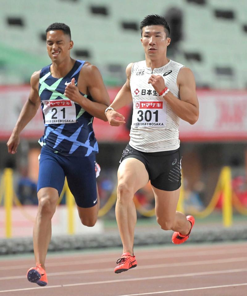 　日本選手権の準決勝、トップでゴールする桐生祥秀。左は悔しがるケンブリッジ飛鳥＝２１年６月