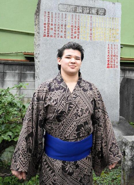 　横綱石碑の前で撮影に応じる砂武蔵