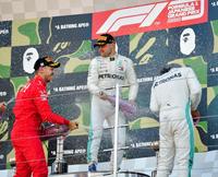 シャンパンファイトで喜びを爆発させる優勝したメルセデスのバルテリ・ボッタス。左は２位のフェラーリのセバスチャン・ベッテル、右は３位のメルセデスのルイス・ハミルトン＝鈴鹿サーキット（撮影・神子素慎一）