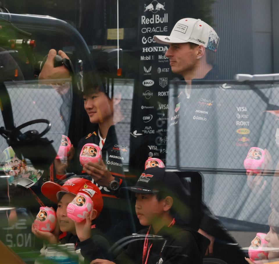 　ホスピタリティブース内で地元小学生らと記念撮影するレッドブル・ホンダの角田裕毅とマックス・フェルスタッペン（右）＝撮影・神子素慎一
