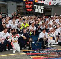 　レッドブル・ホンダのマックス・フェルスタッペンの勝利を祝い記念撮影するレッドブルチーム。左手前はレッドブルシャワーから逃げ出す角田裕毅（撮影・神子素慎一）