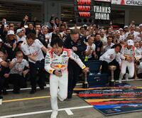 　レッドブル・ホンダのマックス・フェルスタッペン（右端）の勝利を祝い記念撮影するレッドブルチーム。左手前はレッドブルシャワーから逃げ出す角田裕毅（撮影・神子素慎一）