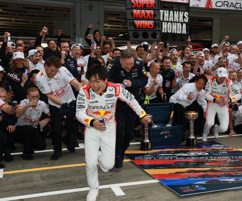 　レッドブル・ホンダのマックス・フェルスタッペン（右端）の勝利を祝い記念撮影するレッドブルチーム。左手前はレッドブルシャワーから逃げ出す角田裕毅（撮影・神子素慎一）