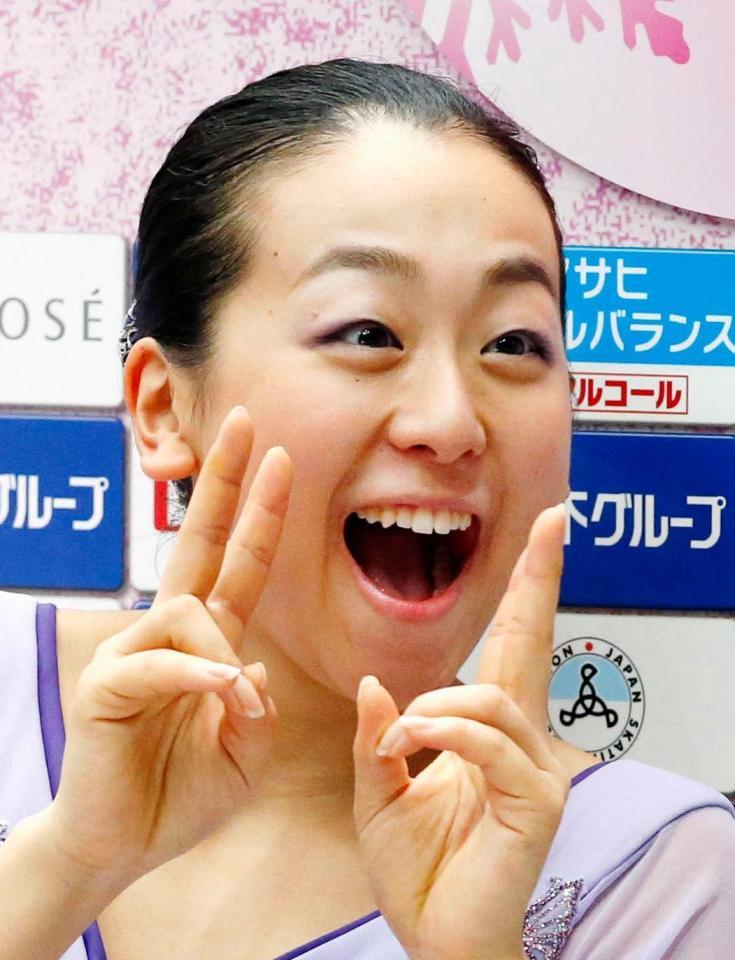 日本チームの優勝が決まり、Ｖサインで笑顔の浅田真央＝さいたまスーパーアリーナ