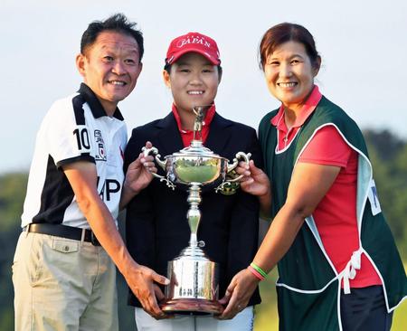 　アマチュアで国内メジャー初制覇を果たした畑岡奈紗（中央）は、父親の仁一さん（左）、母親でキャディーを務める博美さんと優勝トロフィーを手に笑顔を見せる