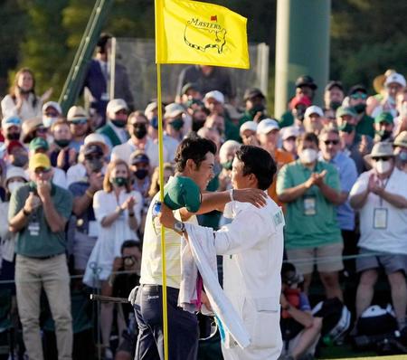 米ゴルフのマスターズ・トーナメントで、日本男子初のメジャー制覇を果たし、キャディー（手前右）と抱き合う松山英樹＝オーガスタ・ナショナルＧＣ（ＡＰ＝共同）