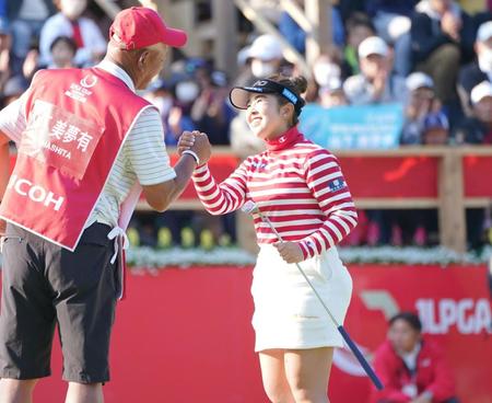 　１８番、ウイニングパットを沈め松村卓キャディー（左）と握手を交わす山下美夢有（撮影・開出牧）