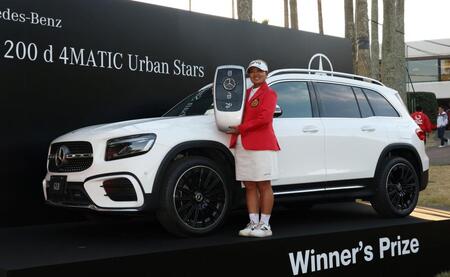 　優勝者に贈られる車を前に笑顔を見せる鈴木愛（撮影・中田匡峻）