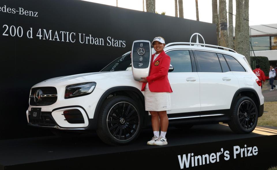 　優勝者に贈られる車を前に笑顔を見せる鈴木愛（撮影・中田匡峻）