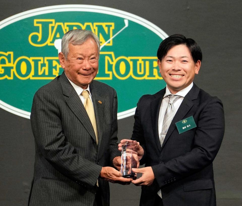　日本ゴルフツアー機構の諸星裕会長（左）から、フェアウエーキープ率賞のトロフィーを受け取る勝亦悠斗