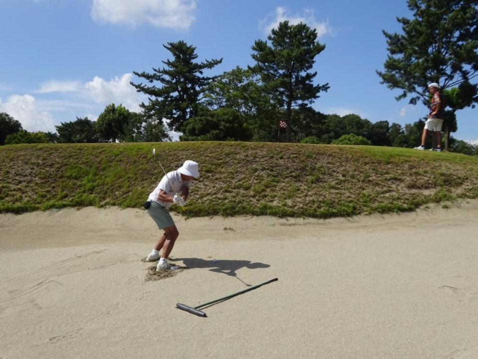 背丈より高いバンカーショットに挑戦する大畑さん