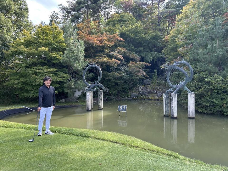 龍神のモニュメントのそばに立つ大畑さん