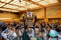 場内を練り歩く御輿に乗せられた尾崎紀世彦さんの遺影(後方中央)=撮影・開出牧