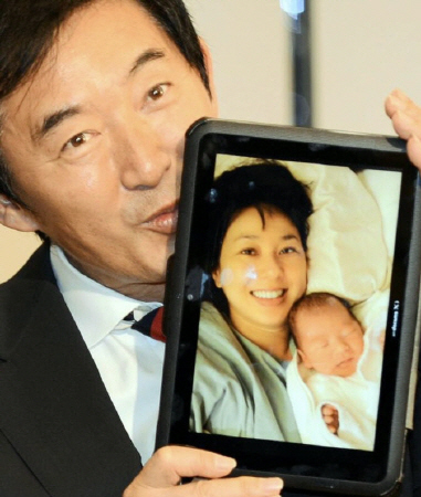 ５日に誕生した赤ちゃんと妻・理子の写真にキスをする石田純一