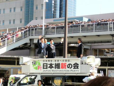 沿道からの声援に手を振って応える日本維新の会、橋下徹代表代行（左）＝ＪＲ高槻駅前