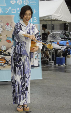 　浴衣姿で打ち水を行った水沢エレナ＝東京都千代田区の東京駅前