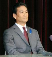 神妙な表情で復帰会見を行った辛坊治郎氏。左胸には青い羽根が