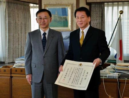　谷垣禎一法務大臣から表彰状をもらい、笑顔を見せる杉良太郎＝法務省