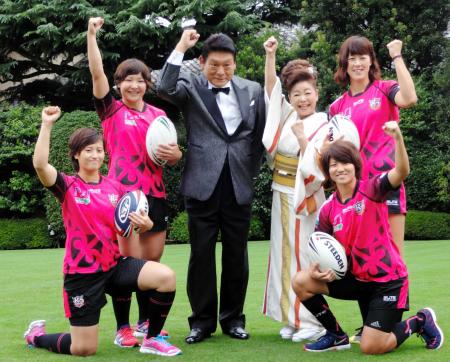 　女子ラグビー選手たちとポーズする増位山太志郎（左）と中村美律子＝明治記念館