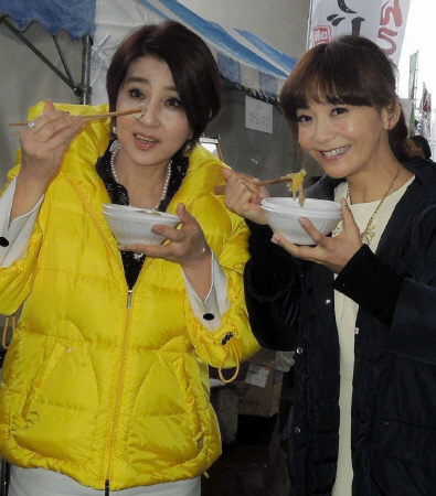 福島県の食材で作った鍋料理を堪能する秋吉久美子（左）と華原朋美＝福島県郡山市のビッグパレットふくしま