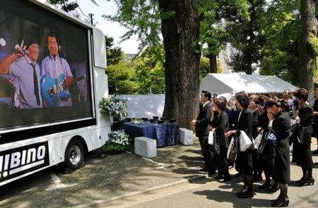 加瀬邦彦さんの生前の姿を見ながら「旅人よ」を歌う参列ファン＝東京・護国寺