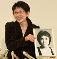二十歳の頃の萩原流行さんの写真を手に会見に臨んだ妻・まゆ美さん＝東京・霞ヶ関の弁護士会館