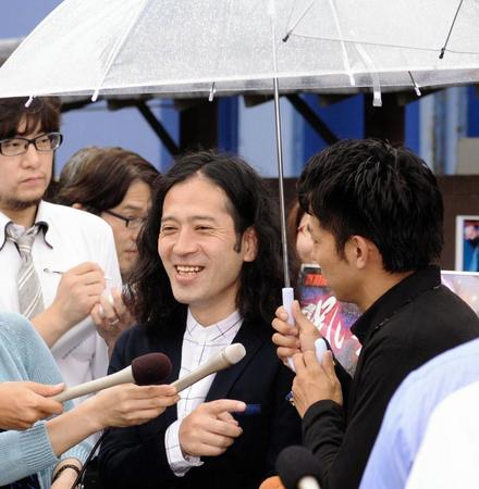 芥川賞発表直前のイベントで又吉（左）のために傘をさす綾部＝７月１６日撮影