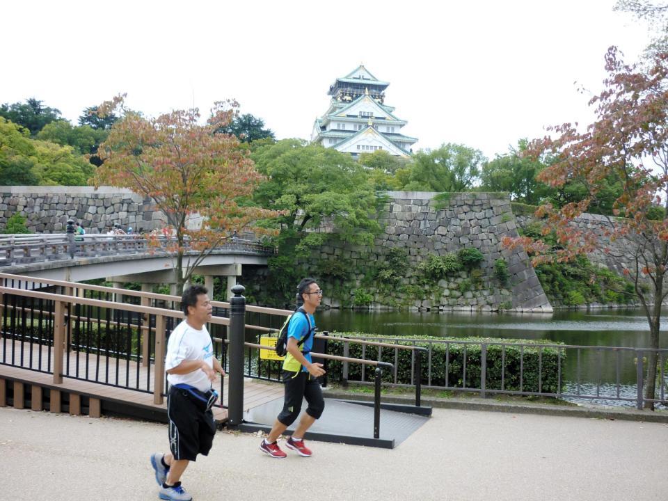 大阪城の前でマラソンの練習に励むジミー大西（手前）