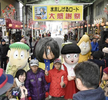 　「水木しげるロード」で開かれた大感謝祭で、着ぐるみの妖怪たちと記念撮影をする子どもら＝鳥取県境港市