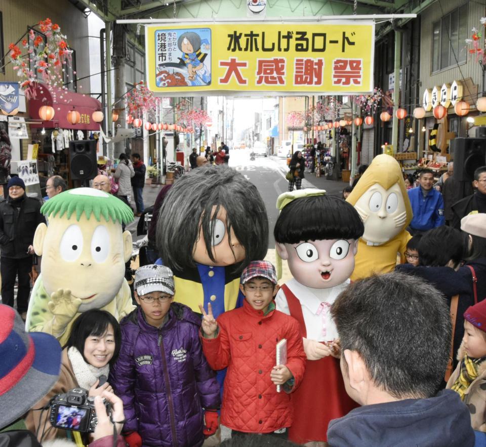 　「水木しげるロード」で開かれた大感謝祭で、着ぐるみの妖怪たちと記念撮影をする子どもら＝鳥取県境港市