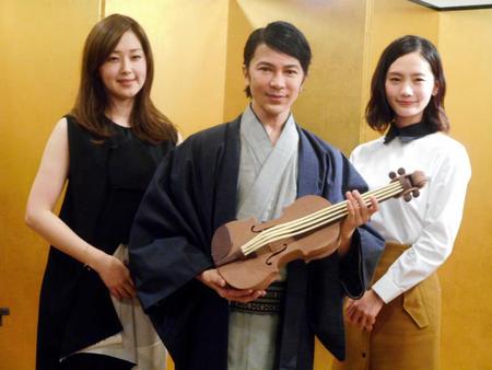 　笛木優子（左）と中村ゆり（右）から贈られたチョコレートのバイオリンを抱える武田真治（中央）＝東京・銀座