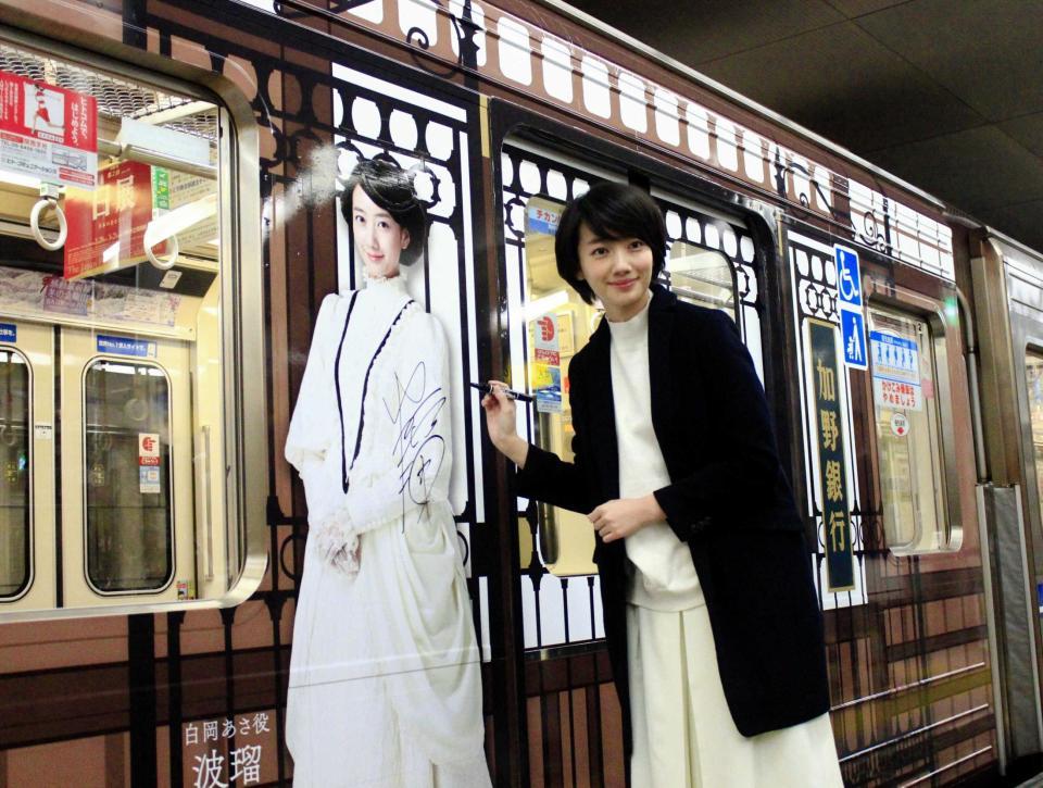 　「あさが来た」のラッピングが施された地下鉄にサインを入れる波瑠＝大阪・西梅田駅