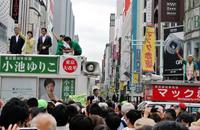 緑色ファッションのマック赤坂氏（右）からエールを送られた小池百合子氏＝東京・銀座
