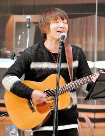 ギターの弾き語りで歌声を響かせた宮田和弥＝横浜・日産グローバル本社