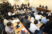 　大勢の報道陣を前に会見する神戸市立東須磨小学校の仁王美貴校長（右奥）ら＝神戸市役所