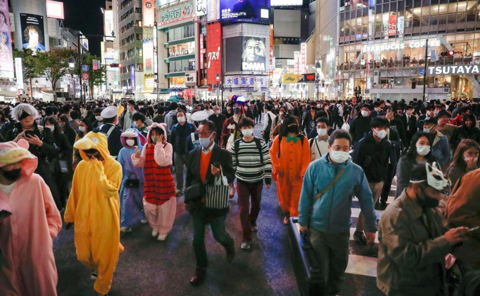 ハロウィーン本番を迎え、東京・渋谷のスクランブル交差点を行き交う人たち＝31日夜