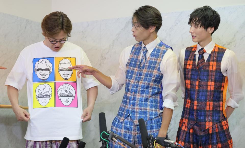 　辞めたメンバーの顔が描かれたＴシャツを着て会見する純烈の酒井一圭（左）。中央は白川裕二郎、右は後上翔太（撮影・吉澤敬太）