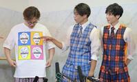 　脱退したメンバーの顔が描かれたＴシャツを着て会見する酒井一圭（左）