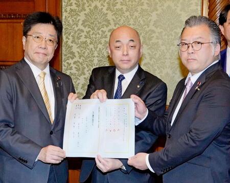 　衆院議員定数を削減するための法案を衆院の築山信彦事務総長（中央）に共同提出する自民党の加藤勝信政治制度改革本部長（左）と日本維新の会の浦野靖人選対委員長代行＝５日