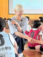 　金髪が超お似合い！イベントに出演し児童と握手する江村美咲＝２０２５年９月撮影