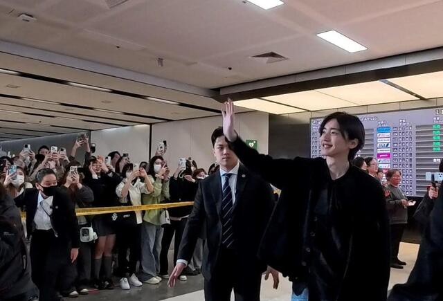 到着した空港で歓迎を受ける道枝駿佑©２０２６「君が最後に遺した歌」製作委員会