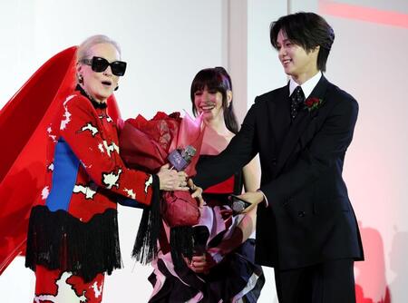 ６日に＆ＴＥＡＭ・Ｋ（右）から花束を受け取るメリル・ストリープ（中央はアン・ハサウェイ）＝撮影・伊藤笙子