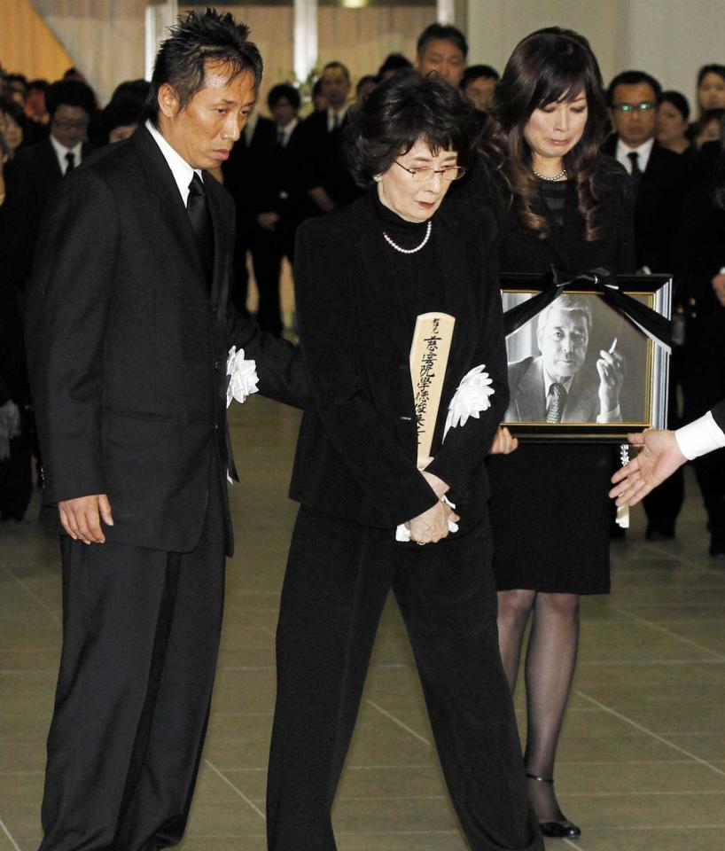 　二谷さんの葬儀で長渕剛（左）に付き添われ、友里恵さん（右）とファンにあいさつ＝２０１２年１月