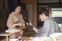 笑顔で「ビア」をヘブン（トミー・バストウ）に差し出すトキ（高石あかり）