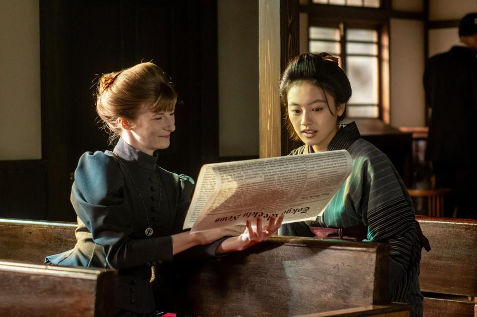 宣教師・メアリー（アニャ・フロリス）と、英字新聞で捨松の結婚披露の記事を読む直美（上坂樹里）