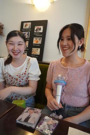 推しの写真やグッズを前に韓国アイドルについて語る箱田朝子さん（左）の佐野愛さん