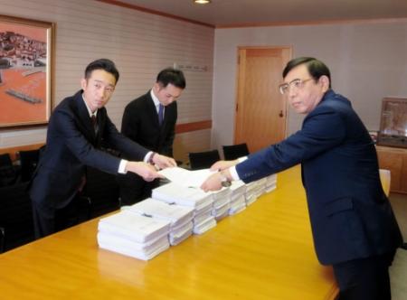 山崎副市長に署名を手渡す永井大介支部長（左）