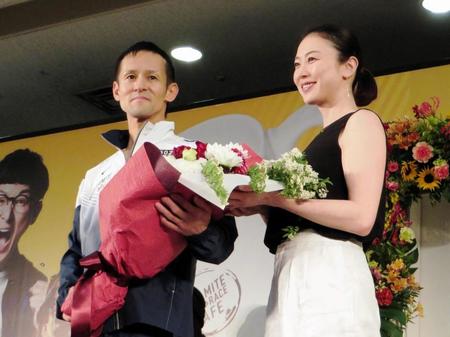 表彰式でシドニー五輪競泳銅メダリストの田中雅美さん（右）から花束を受け取る渡辺英児