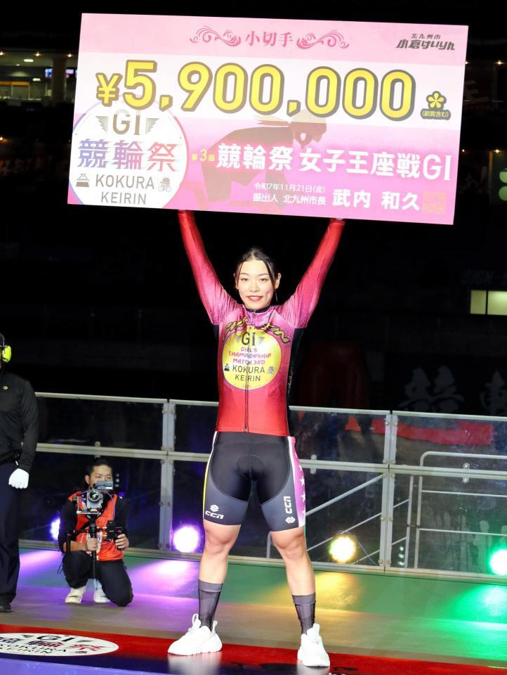 　競輪祭女子王座を制して賞金ボードを高く掲げる佐藤水菜